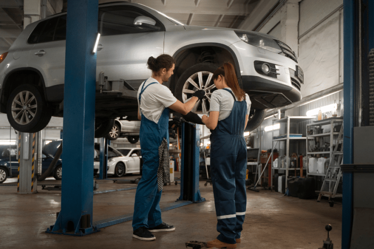 deux garagistes travaillent sur la réparation d'une voiture dans un garage automobile