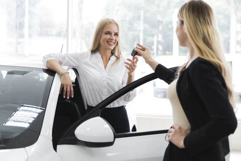 Un loueur de voiture tend les clés à un client.